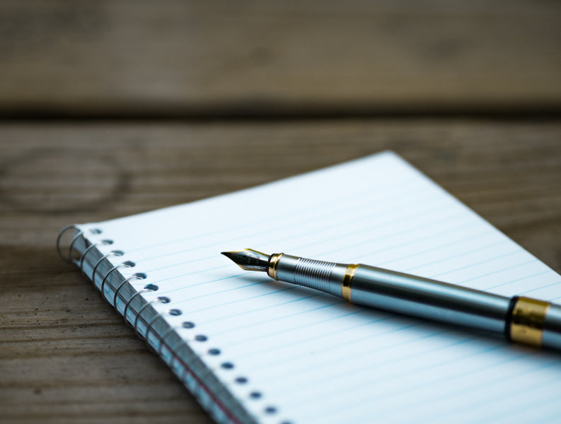 Stylo posé sur un carnet vierge, symbole de l’écriture et de la prise de conscience des émotions
